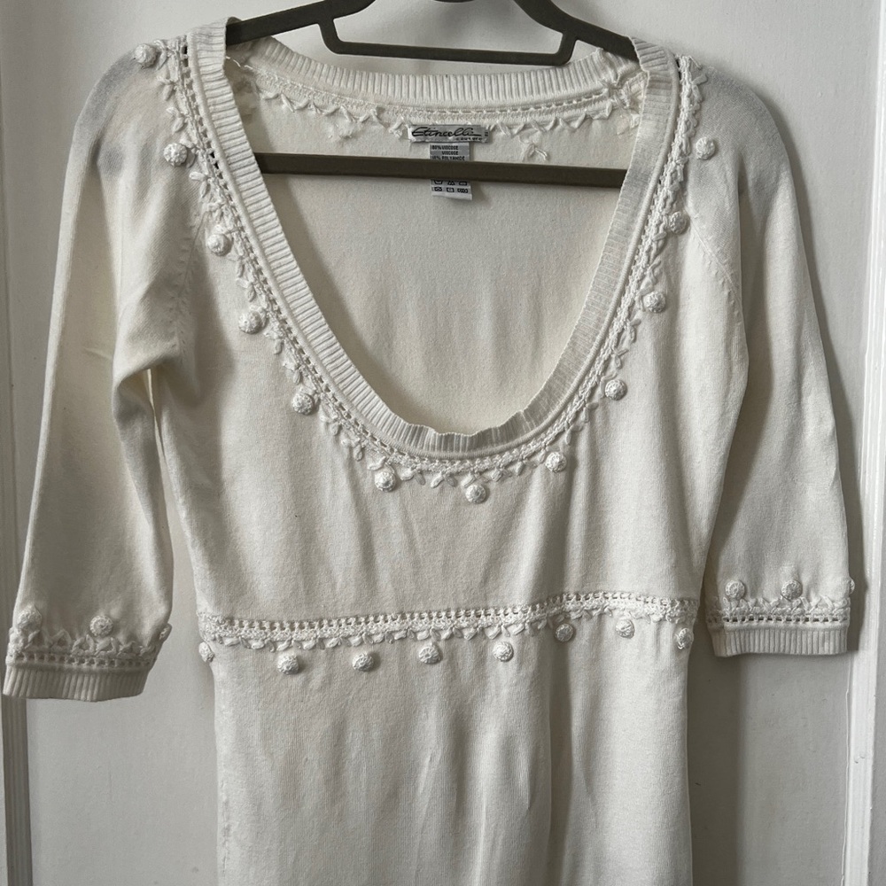 White Knit top with intricate design and stitching.